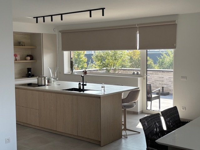 Rolgordijnen op maat in moderne keuken met groot raam