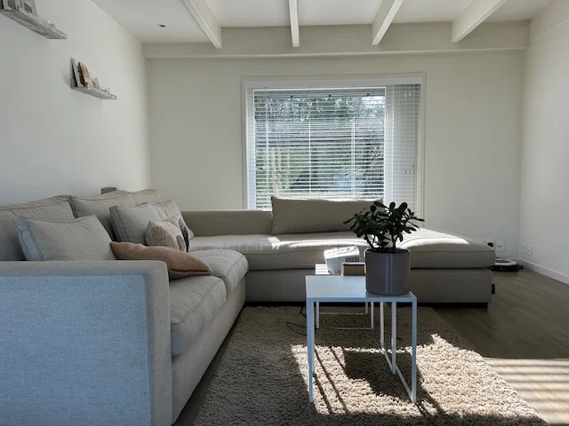 Witte jaloezieën op maat in moderne woonkamer - Raamdecoratie Limburg