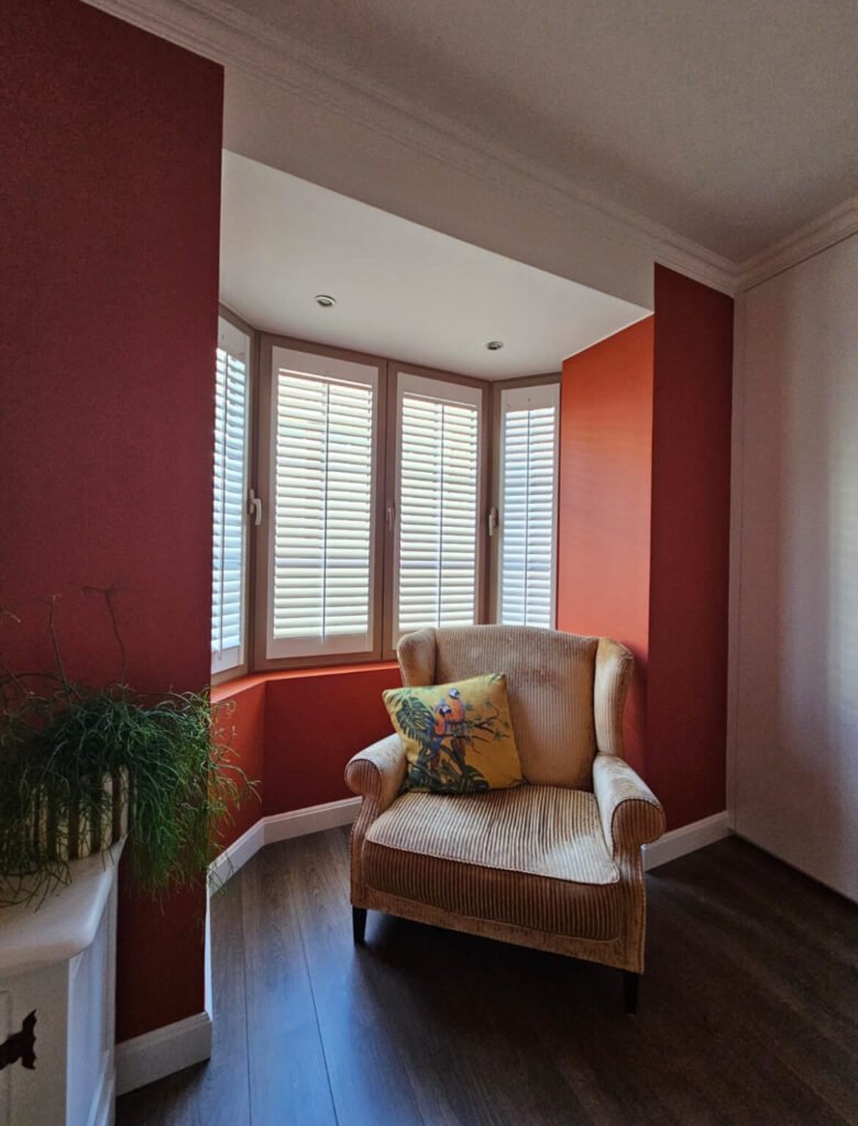 Houten shutters in woonkamer met rode muren
